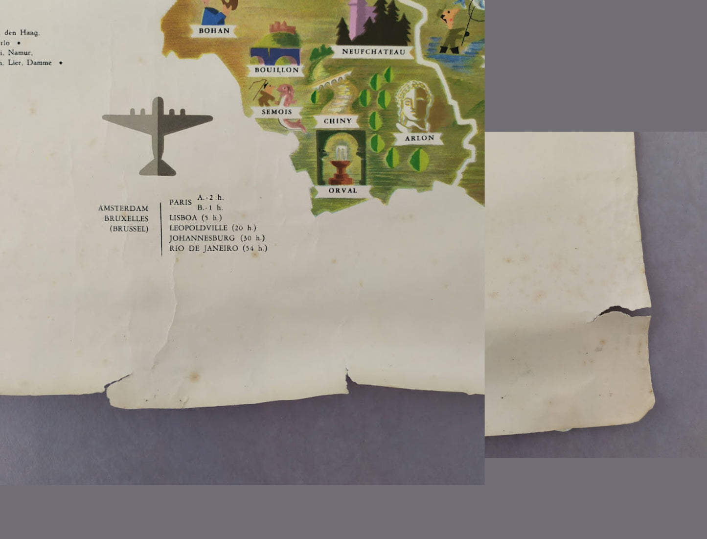 Détail du coin inférieur de l'affiche montrant des déchirures sur le bord du papier et un tableau des temps de vol depuis Bruxelles et Amsterdam.