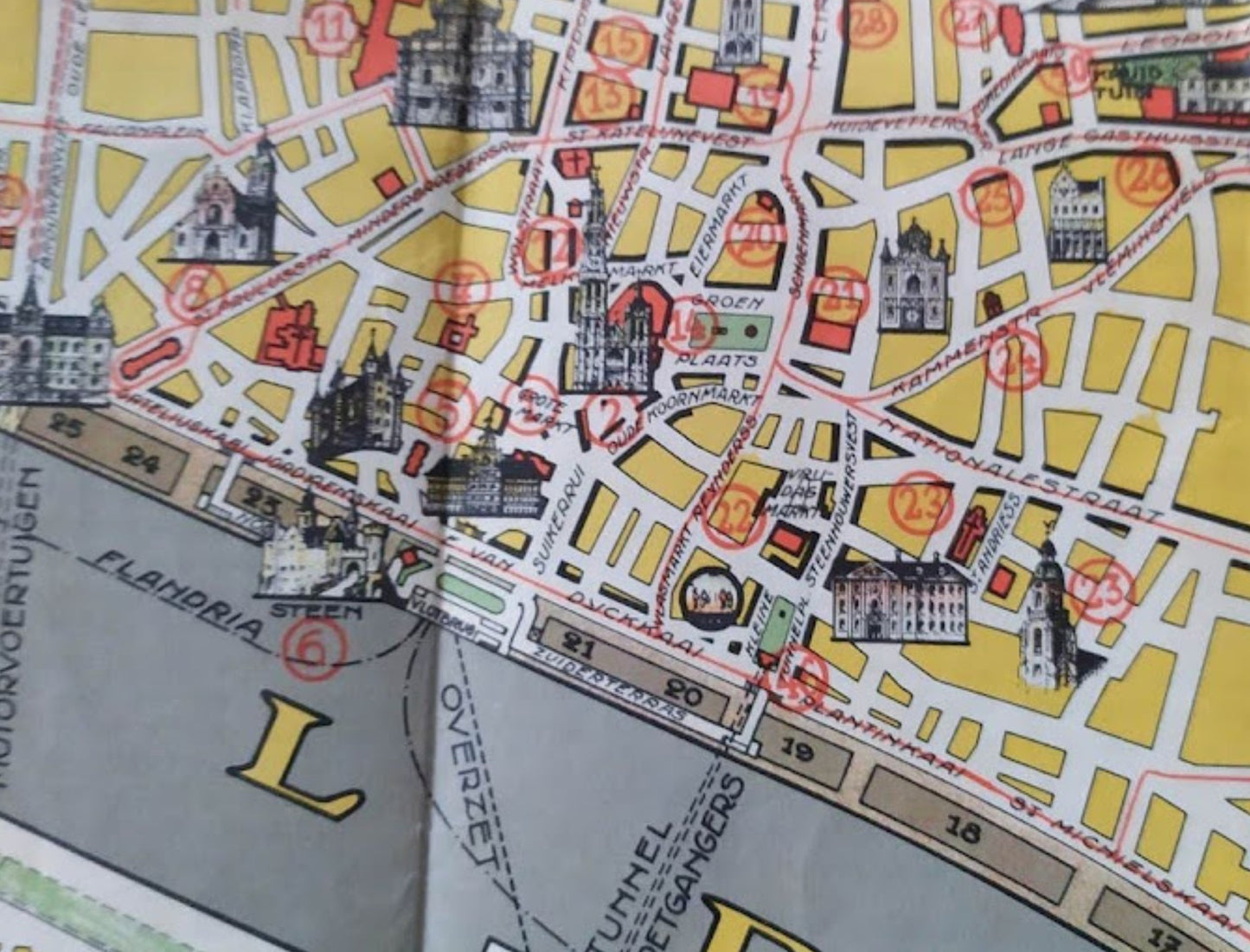 Détail du centre historique d'Anvers avec des petites illustrations de monuments numérotées en rouge, comme la cathédrale et l'hôtel de ville, le long des quais de l'Escaut.