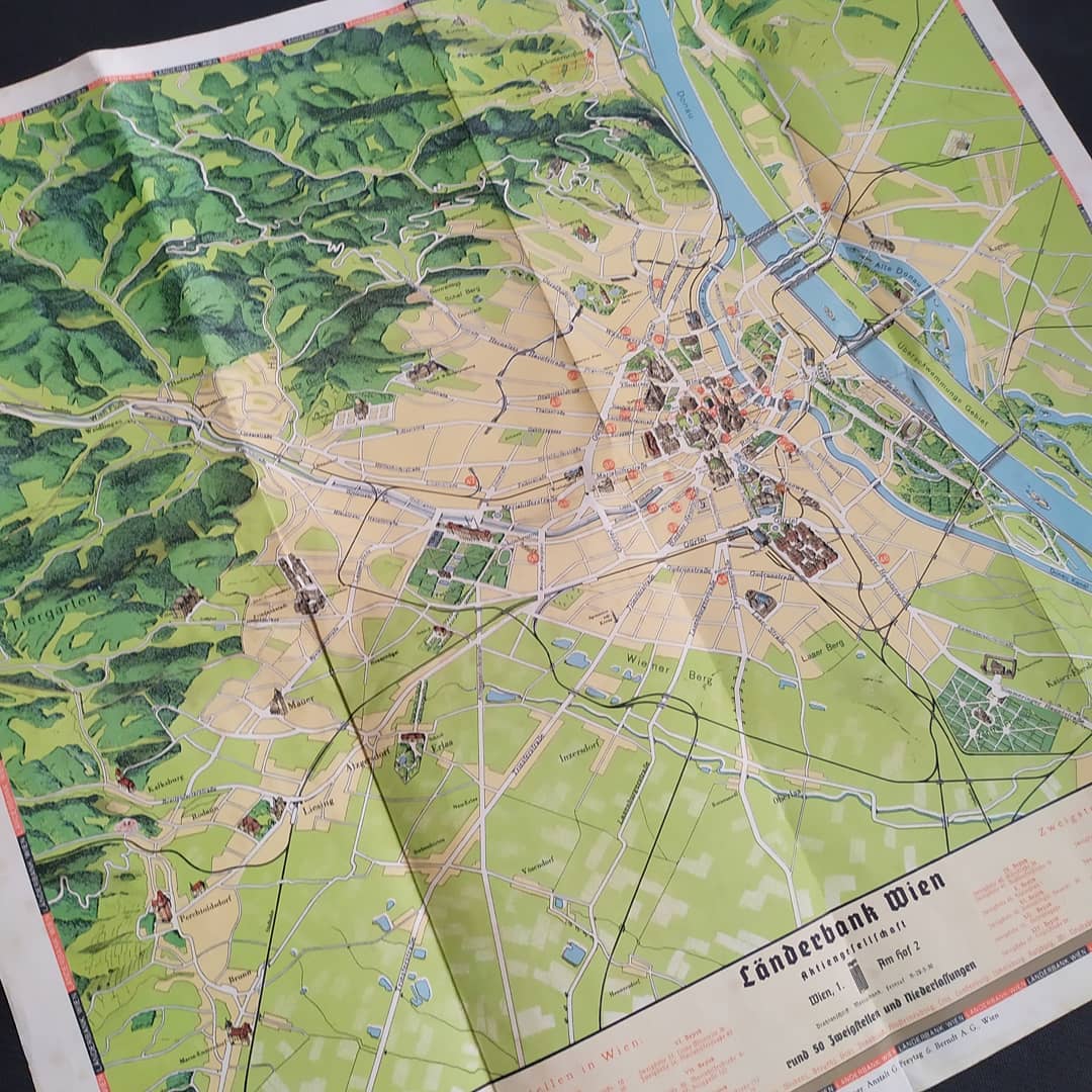 Vue d'ensemble de la carte illustrée de Vienne par Länderbank, pliée en son centre, montrant le fleuve Danube, le centre-ville, et l'encart publicitaire de la Länderbank en bas à droite