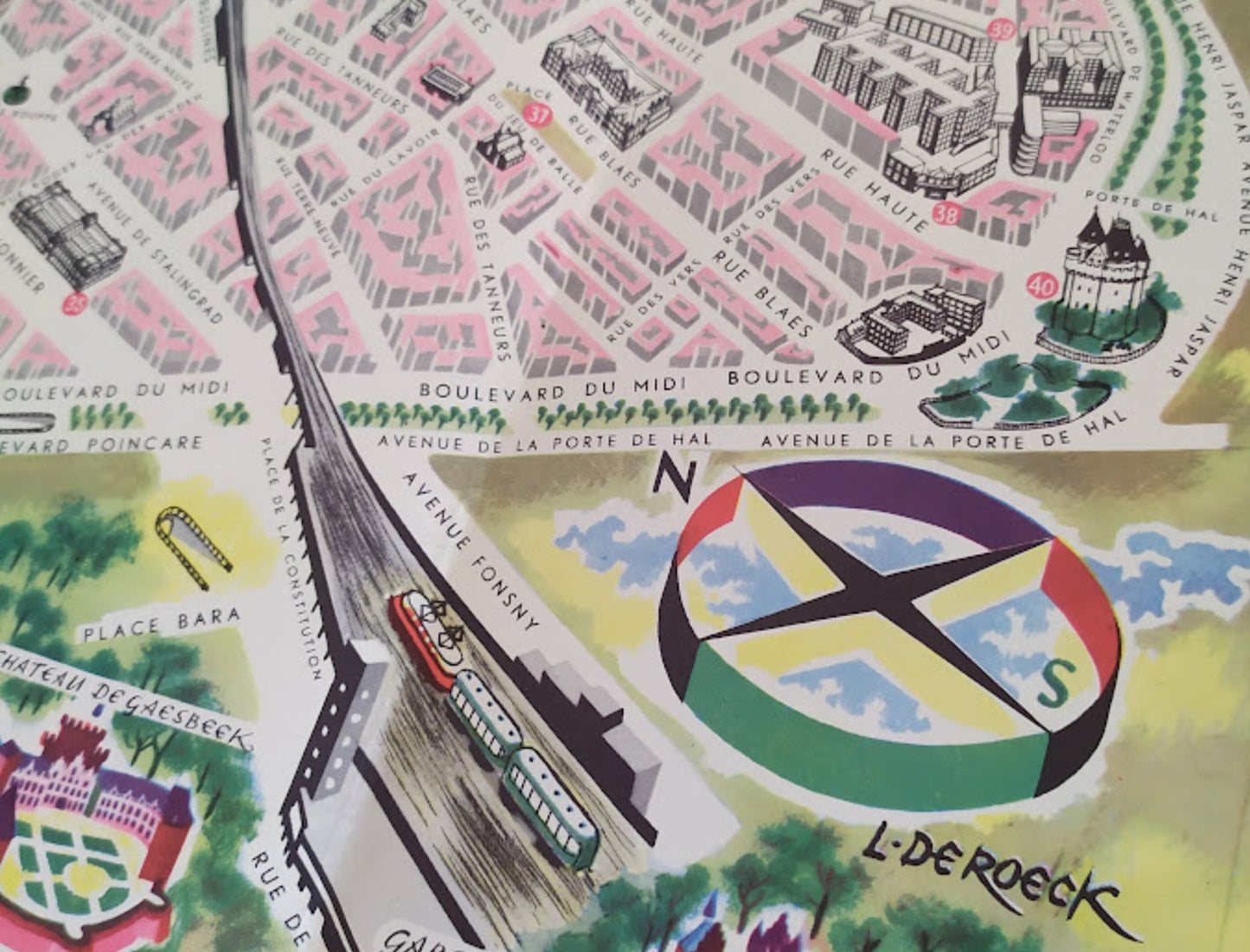Gros plan sur le coin inférieur droit montrant une rose des vents circulaire colorée (jaune, vert, bleu, rouge), la signature "L. DE ROECK" et l'illustration d'un tramway