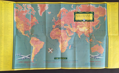 appemonde publicitaire vintage Air France, affichant le réseau aérien mondial avec les illustrations des avions Super Constellation et Vickers Viscount. Les couleurs dominantes sont le vert turquoise, le rose/orange et le jaune. Légende en français et anglais.