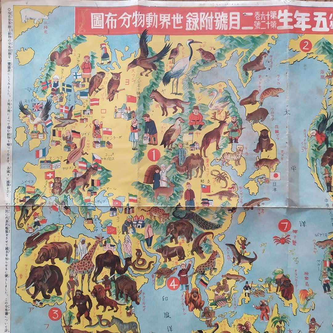 Gros plan sur la partie centrale de la carte picturale japonaise, montrant l'Asie, l'Afrique et l'Europe avec leurs faunes et peuples respectifs.