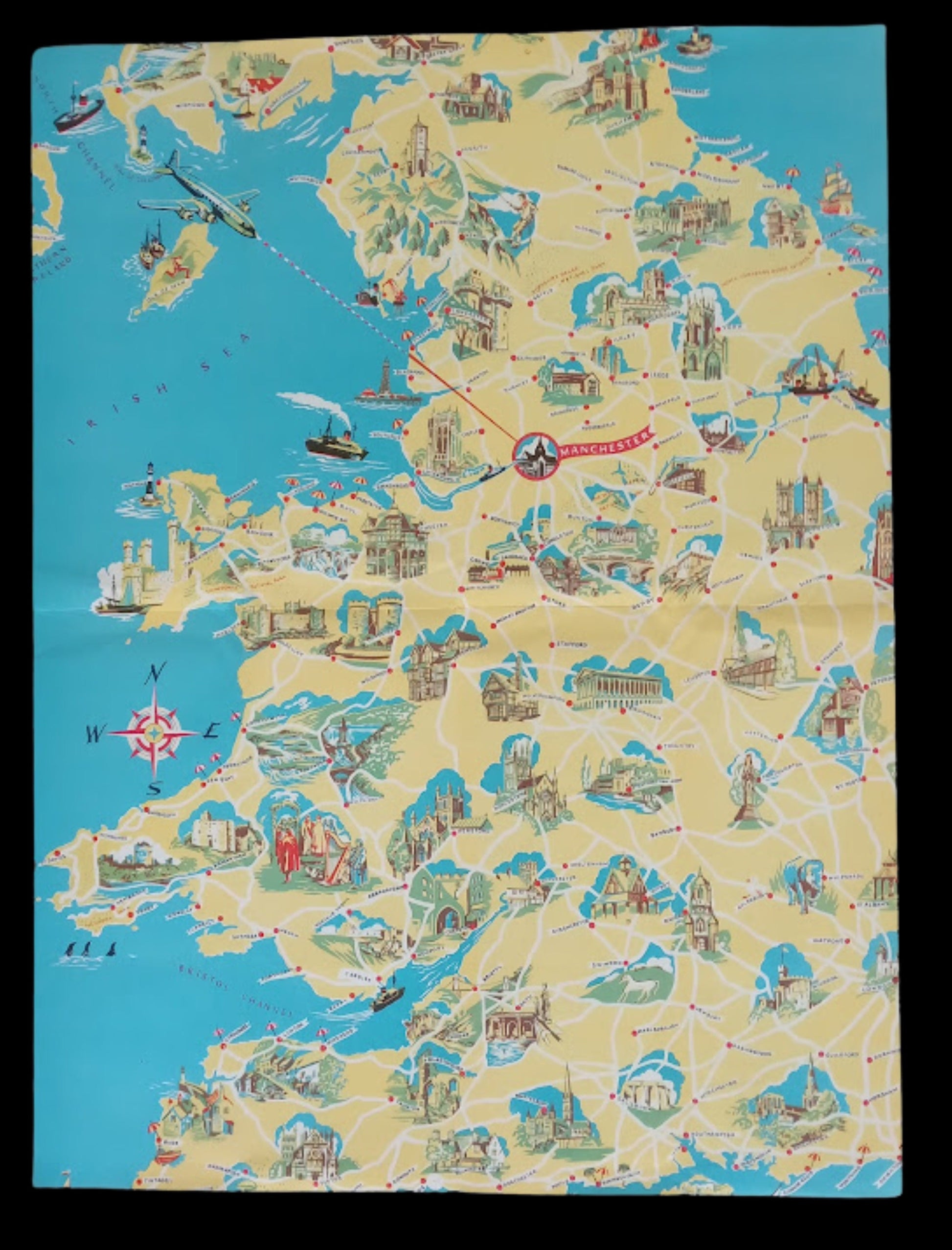 Vue d'ensemble de la carte illustrée montrant Manchester au centre d'un réseau de routes rouges et de villes dessinées sur un fond jaune et bleu. 