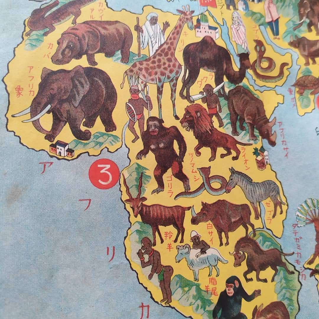 Zoom sur le continent africain sur la carte japonaise, illustré avec des éléphants, girafes, lions, et des représentations de peuples africains.