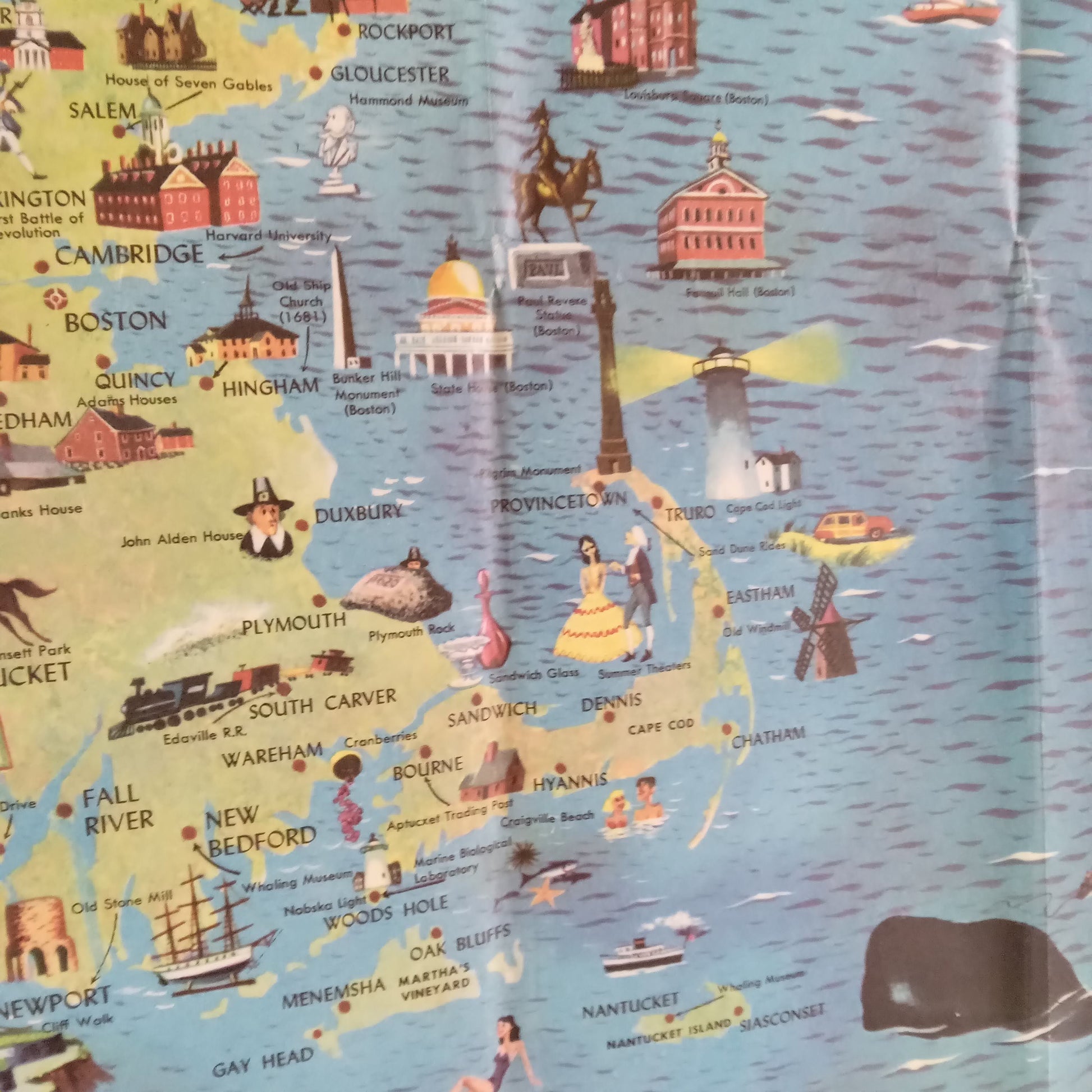 Superbe affiche illustrée dans un style rétro présentant la Nouvelle-Angleterre. Elle couvre les États du Maine, New Hampshire, Vermont, Massachusetts, Rhode Island et Connecticut, avec un accent mis sur les attractions touristiques. Des phares emblématiques, des scènes de pêche au homard, des villes historiques, et des paysages naturels comme le lac Moosehead sont dessinés de manière charmante. La présence de la boussole solaire et des voiliers sur l'Océan Atlantique renforce l'ambiance maritime et aventur