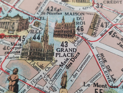 Gros plan sur la zone de la Grand-Place montrant les dessins minutieux de l'Hôtel de Ville, de la Maison du Roi et de la petite statue du Manneken Pis en bas à gauche.
