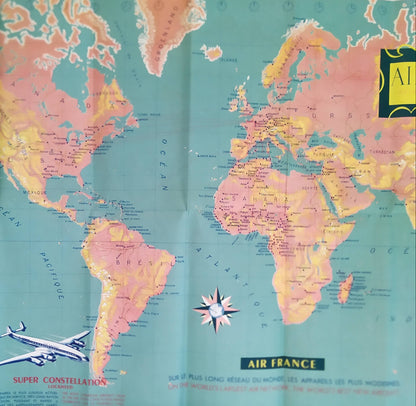 Mappemonde publicitaire vintage Air France, affichant le réseau aérien mondial avec les illustrations des avions Super Constellation et Vickers Viscount. Les couleurs dominantes sont le vert turquoise, le rose/orange et le jaune. Légende en français et anglais.