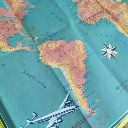 Focus sur la mappemonde publicitaire vintage Air France, affichant le réseau aérien mondial avec les illustrations des avions Super Constellation 