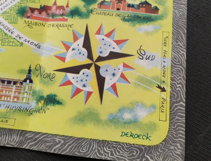 Détail du coin inférieur droit présentant une rose des vents géométrique colorée et la signature de l'artiste "De Roeck" sur un fond jaune avec des nuages stylisés.