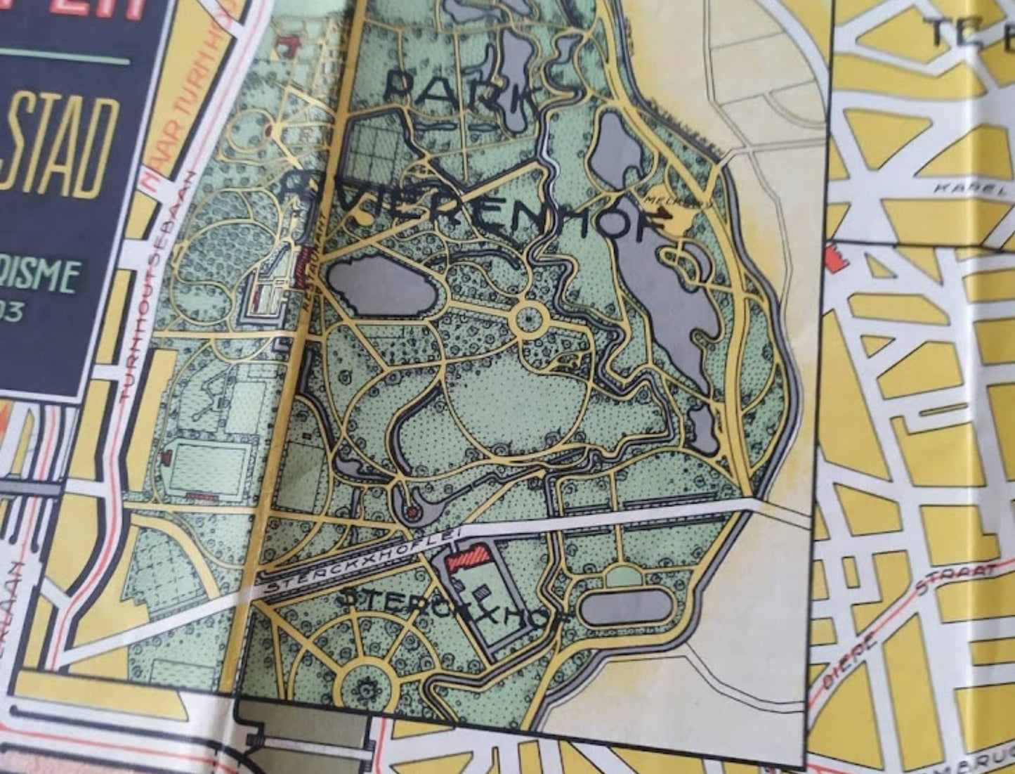 Gros plan sur l'encart du Park Rivierenhof montrant les plans d'eau, les sentiers de promenade et le château Sterckshof dans un style graphique rétro.